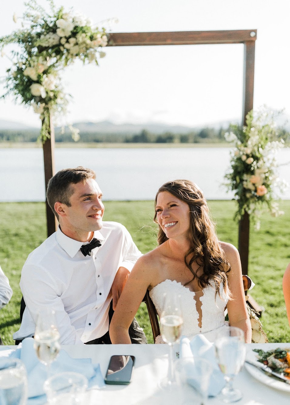 bride and groom sitting down looking at their guests 