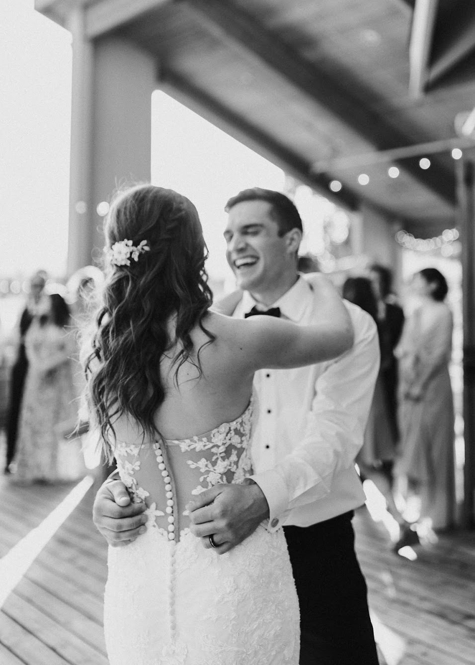 bride and groom outside dancing while their guests watch 