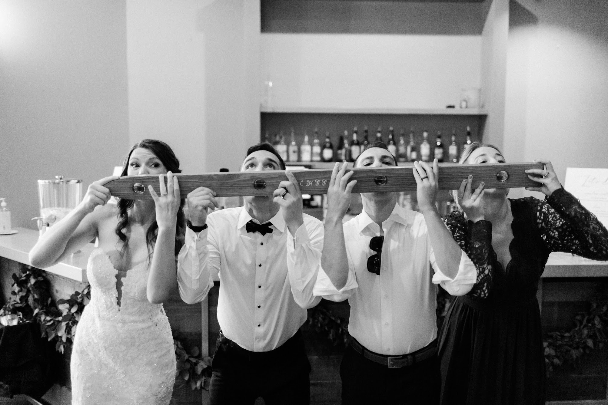 bride, groom and two others taking a ski shot 