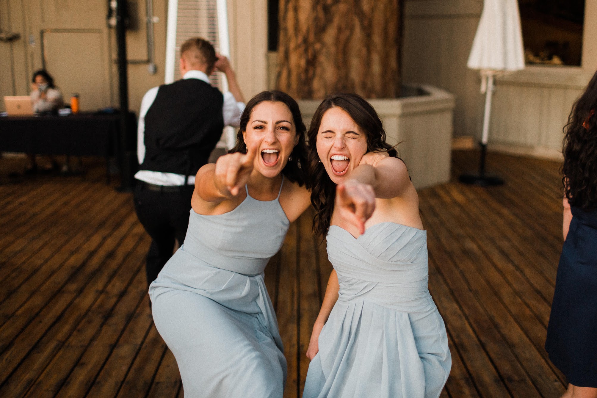 bridesmaid pointing out into the crowd, signing 
