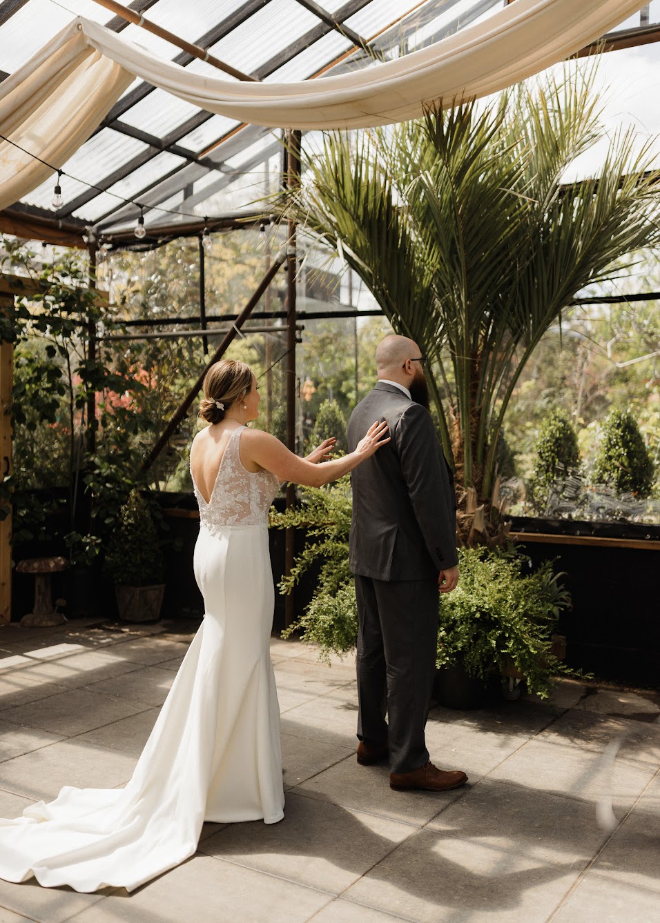 The bride and groom enjoying their first look in a garden.