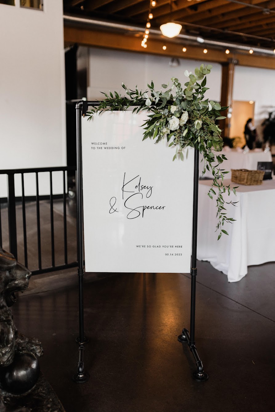 a welcome sign that says "Kelsey and Spencer, We're so glad you're here"