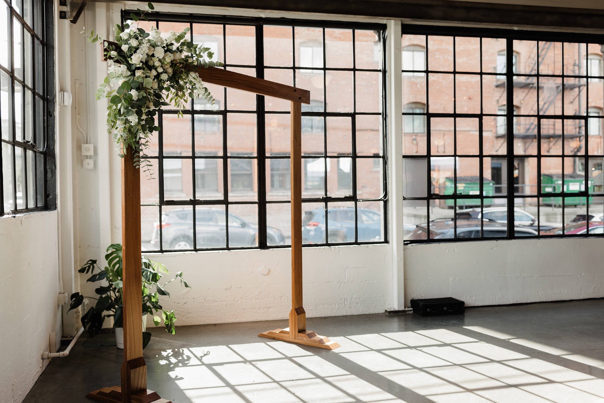 a square wooden arbor with a floral install- the ceremony is set up inside 