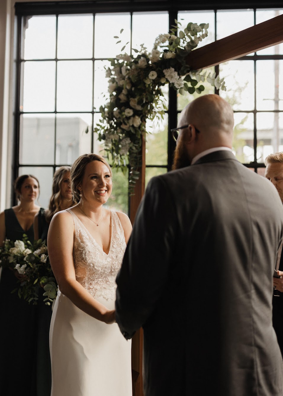bride blushing while holding her grooms' hands. 