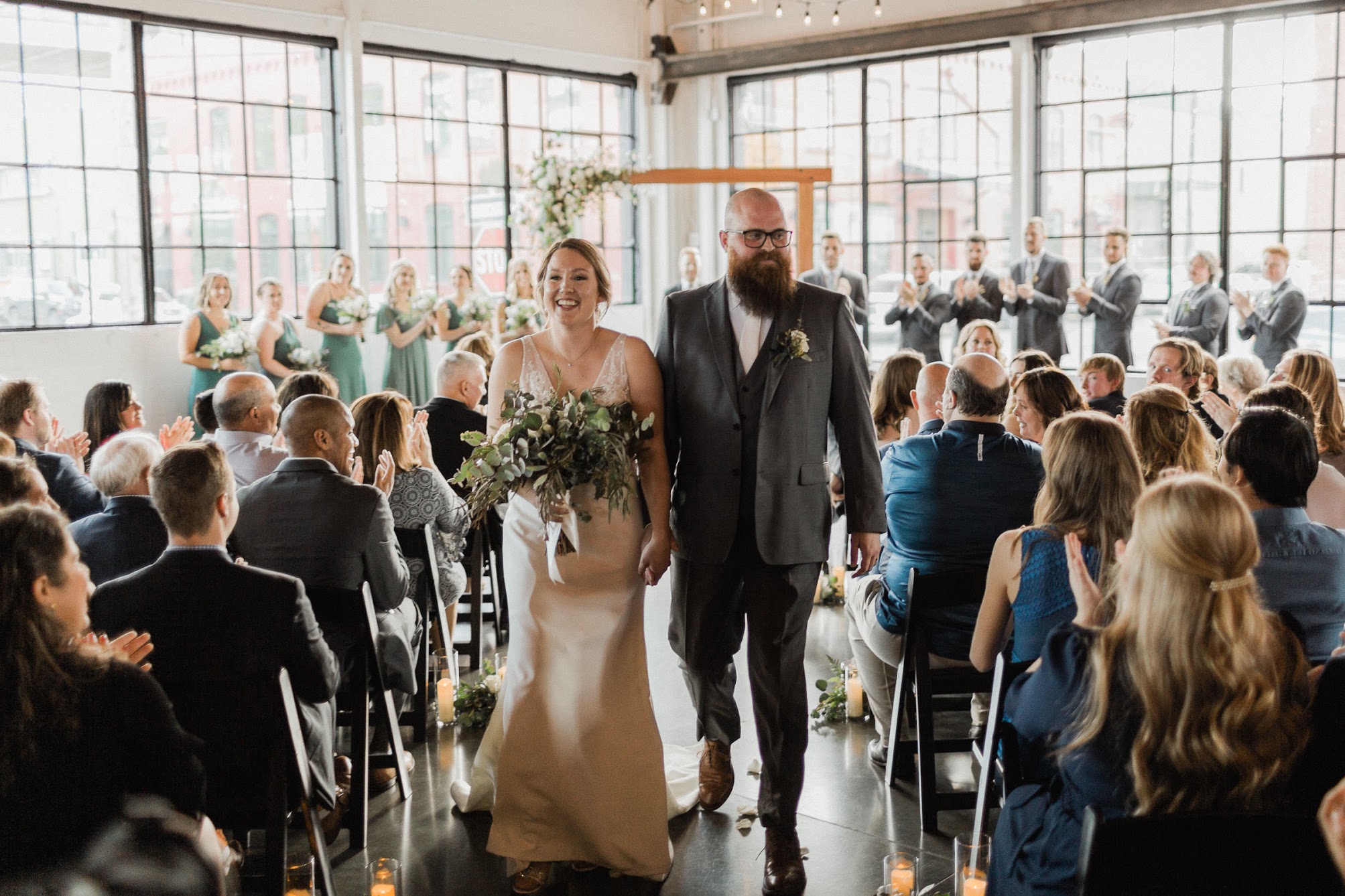 the newly married couple walking down the aisle holding hands