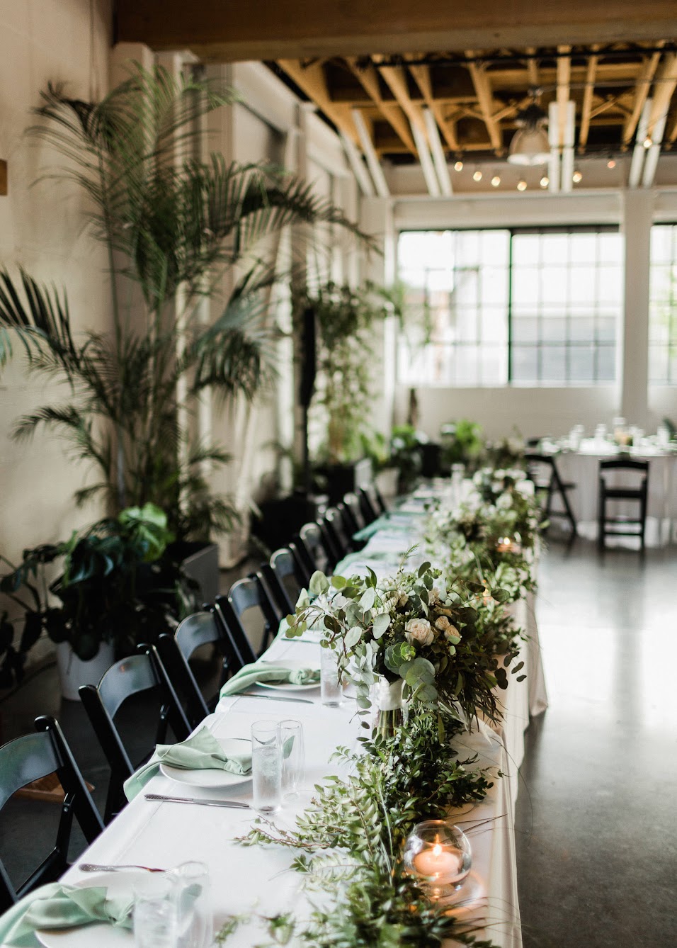stunning head table, long with candles and greenery going all the way to the end of the table 