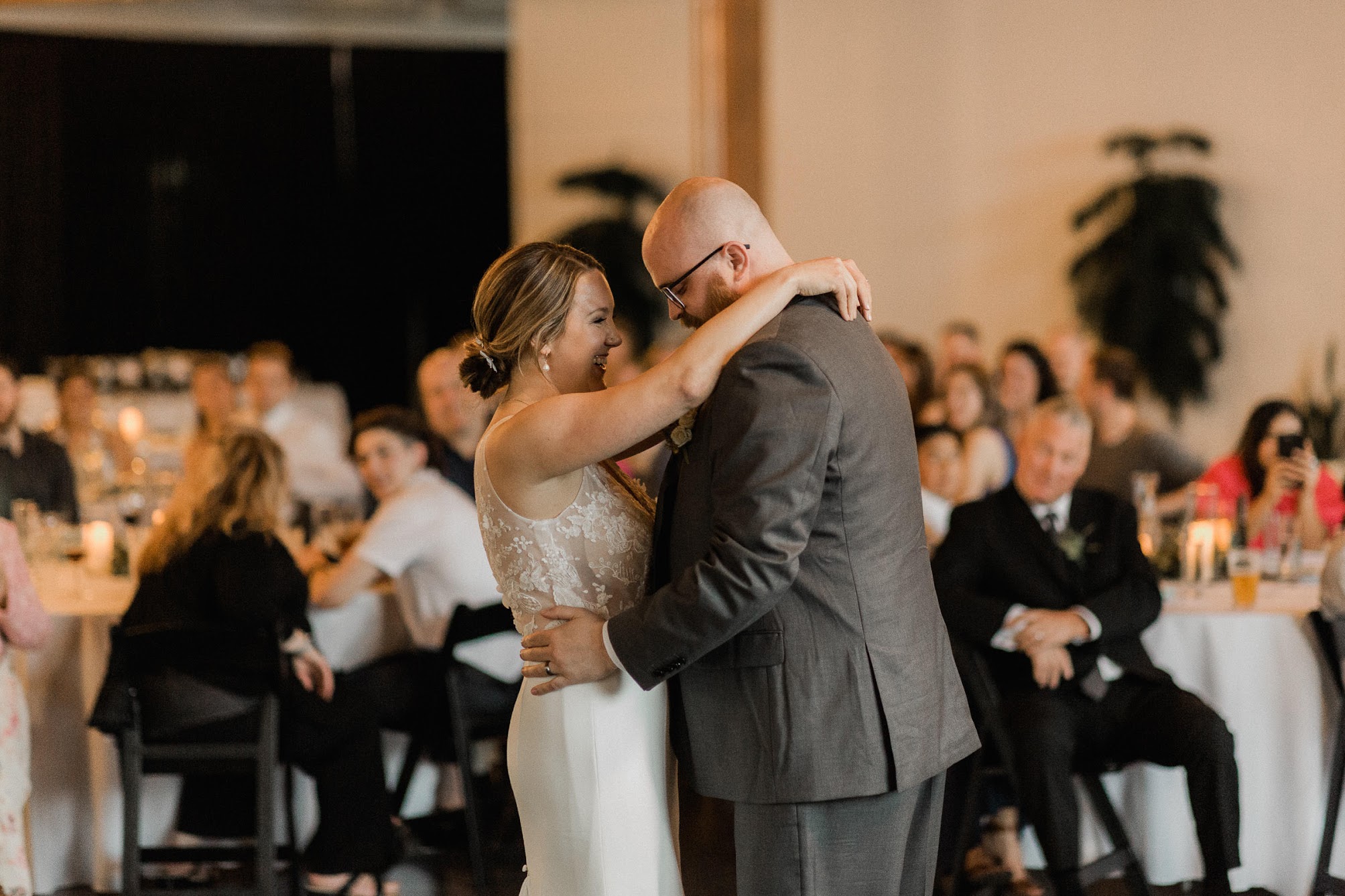 bride and groom holding each other on the dance floor 