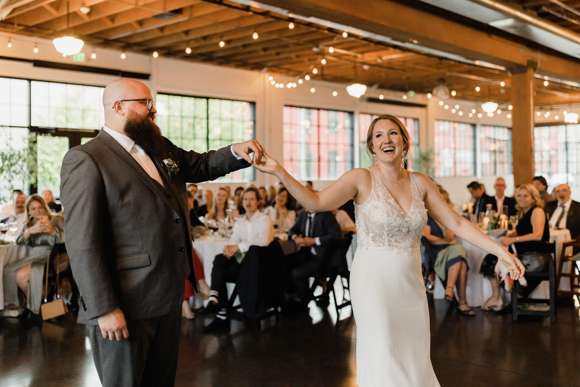 bride dancing around the groom as they hold hands