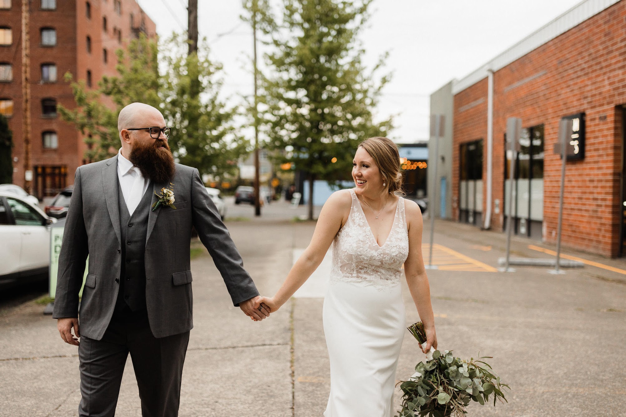 bride and groom walking in the middle of the street 
