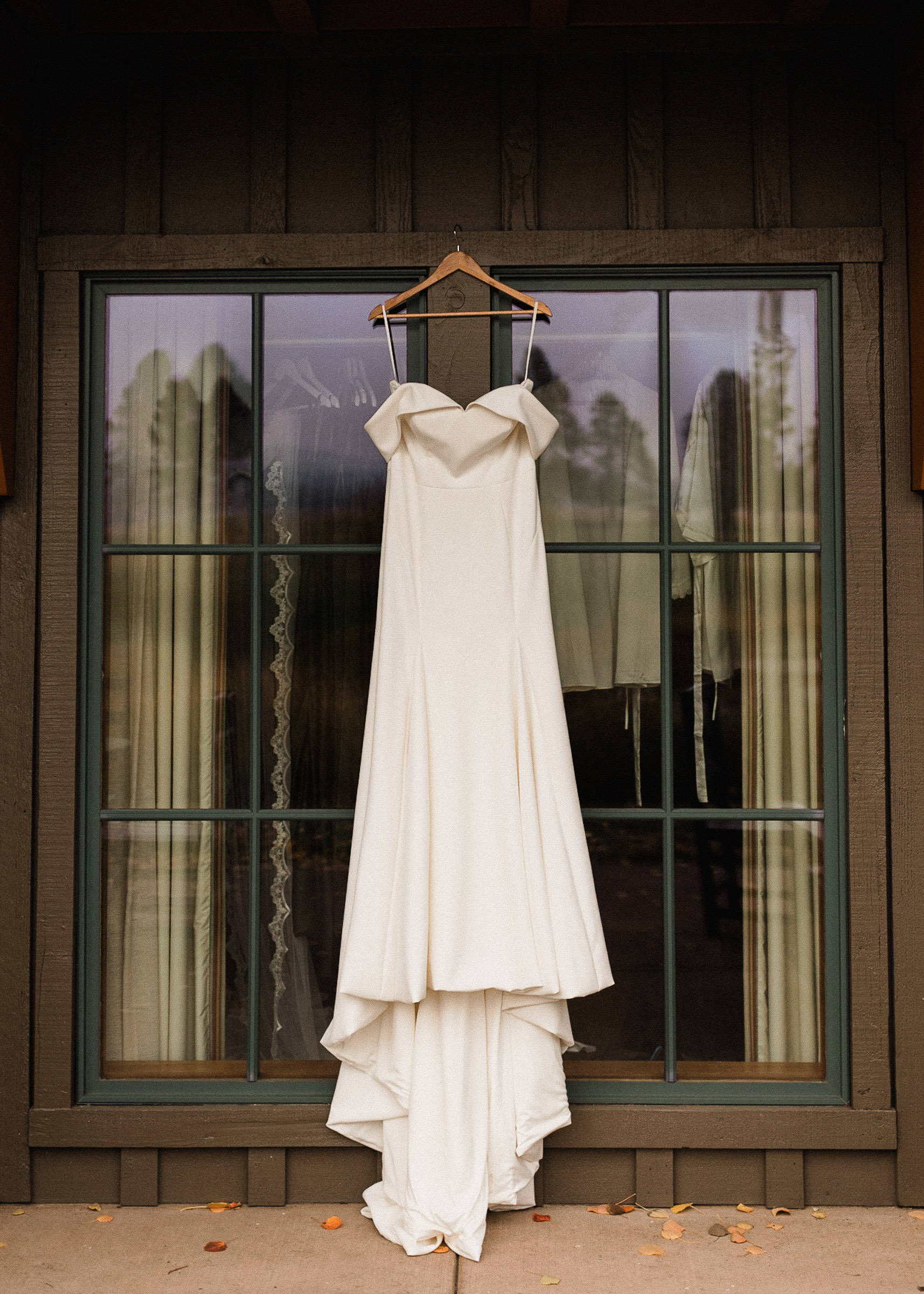 Brides dress hanging in front of windows