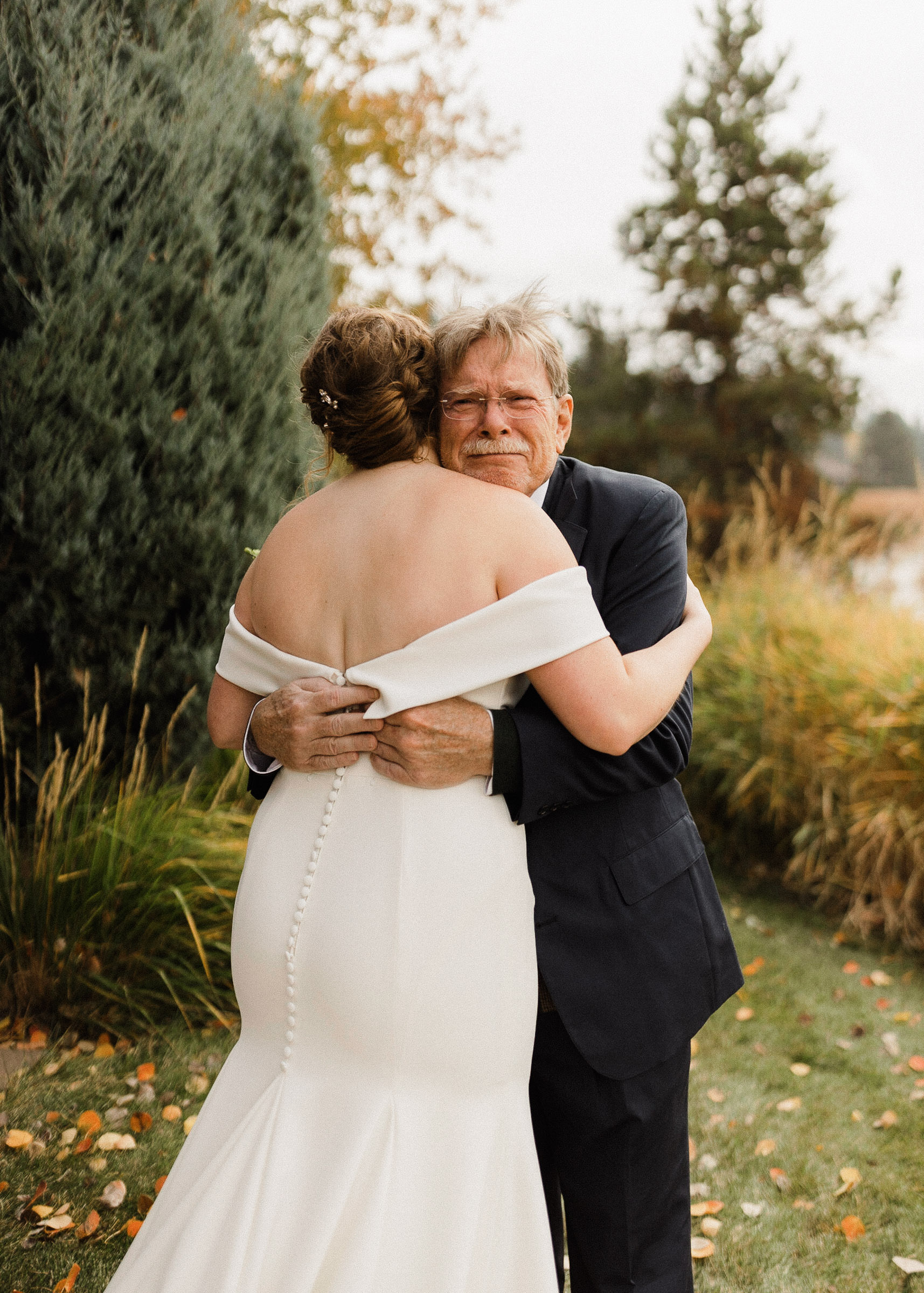 Father reacts emotionally and hugs the bride after seeing her in her wedding dress for the first time