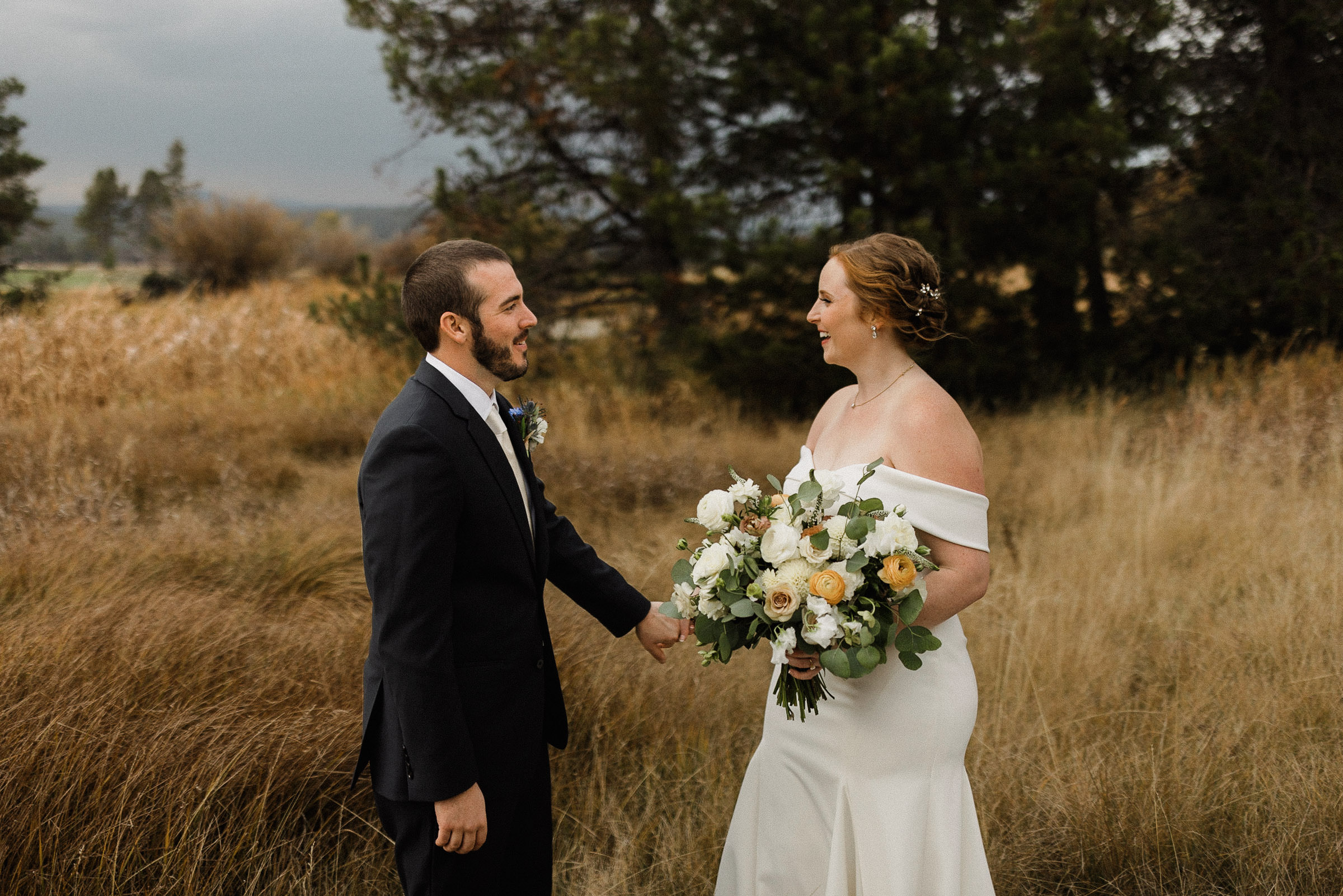 Bride and groom pose for portraits in a field at Sunriver Resort