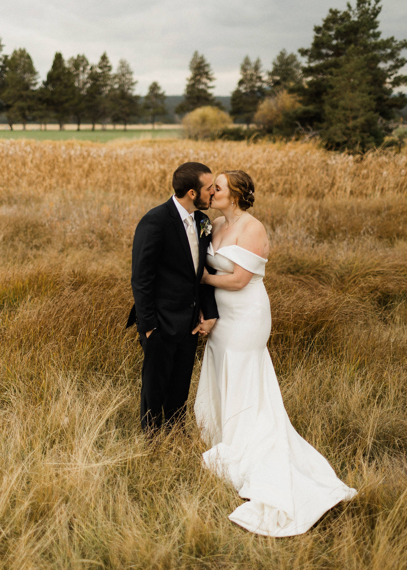 Bride and groom pose for portraits in a field at Sunriver Resort