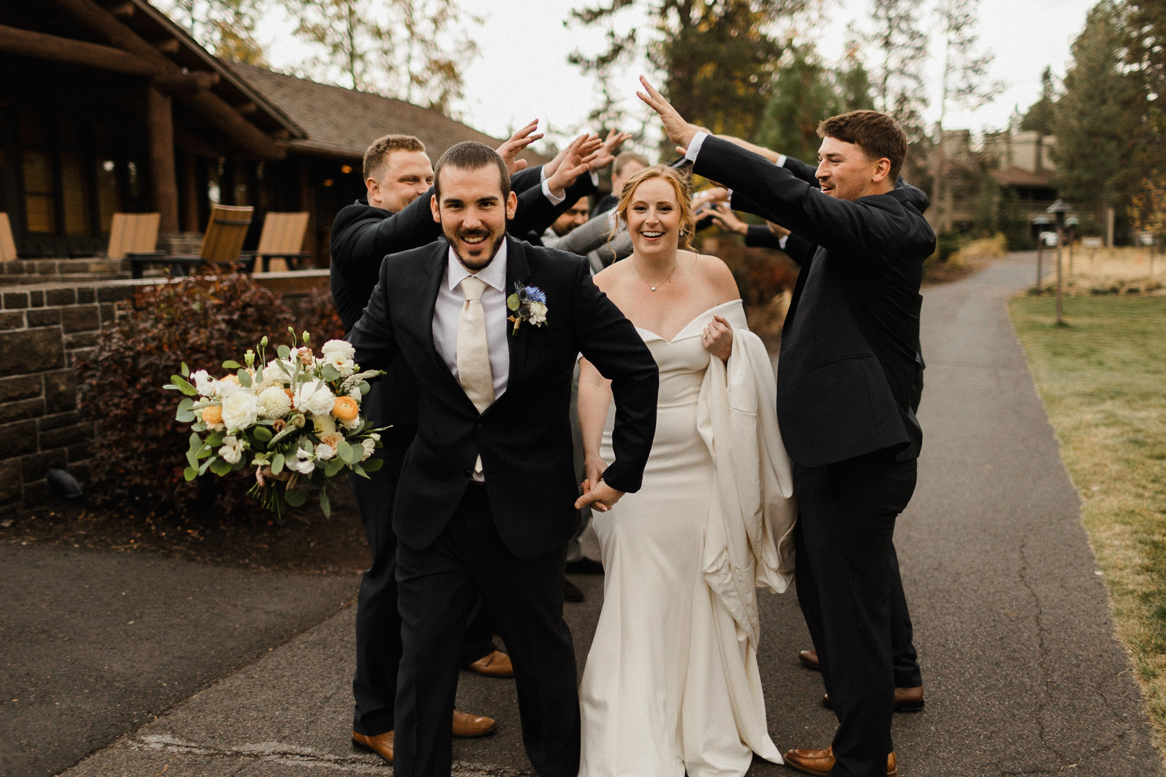 Bride and groom walk through a tunnel created by the groomsmen