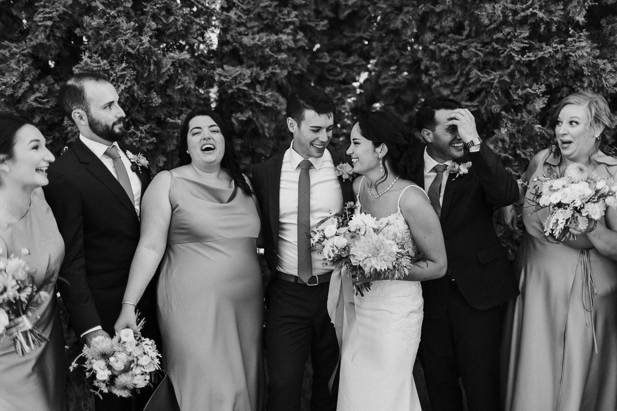 Wedding party standing in a row, laughing