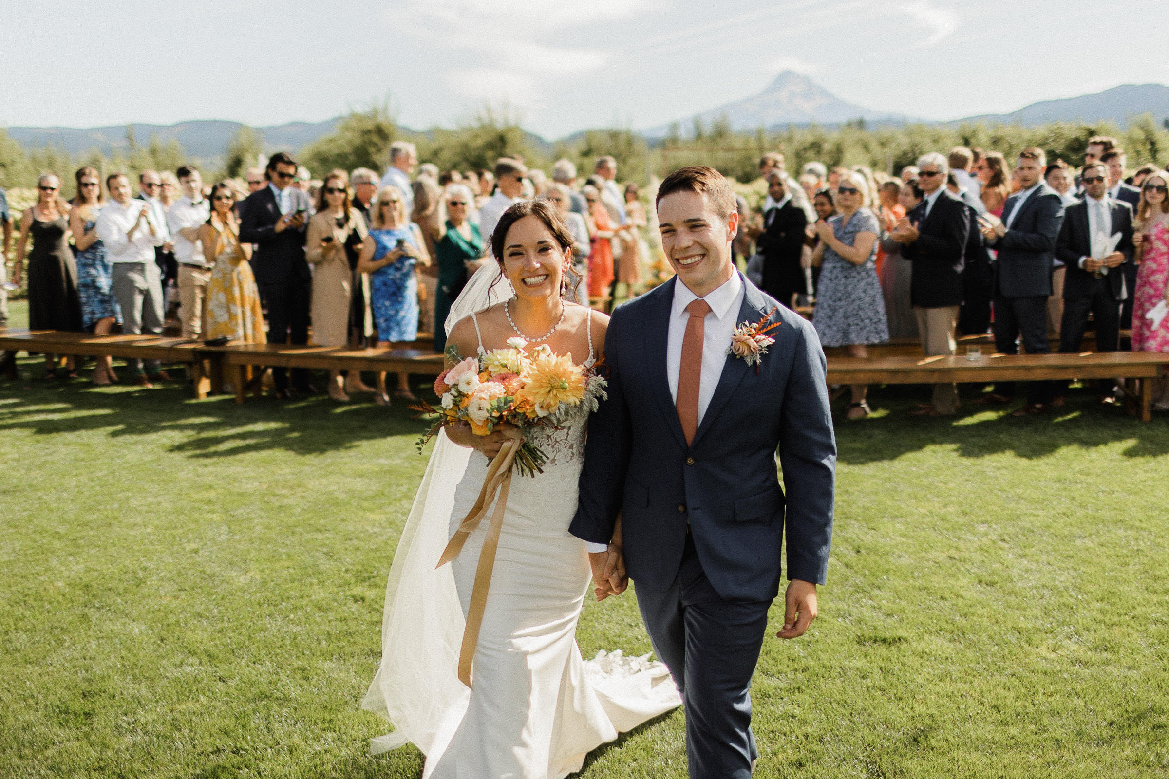 Bride and groom smile as they recess down the aisle after their wedding ceremony