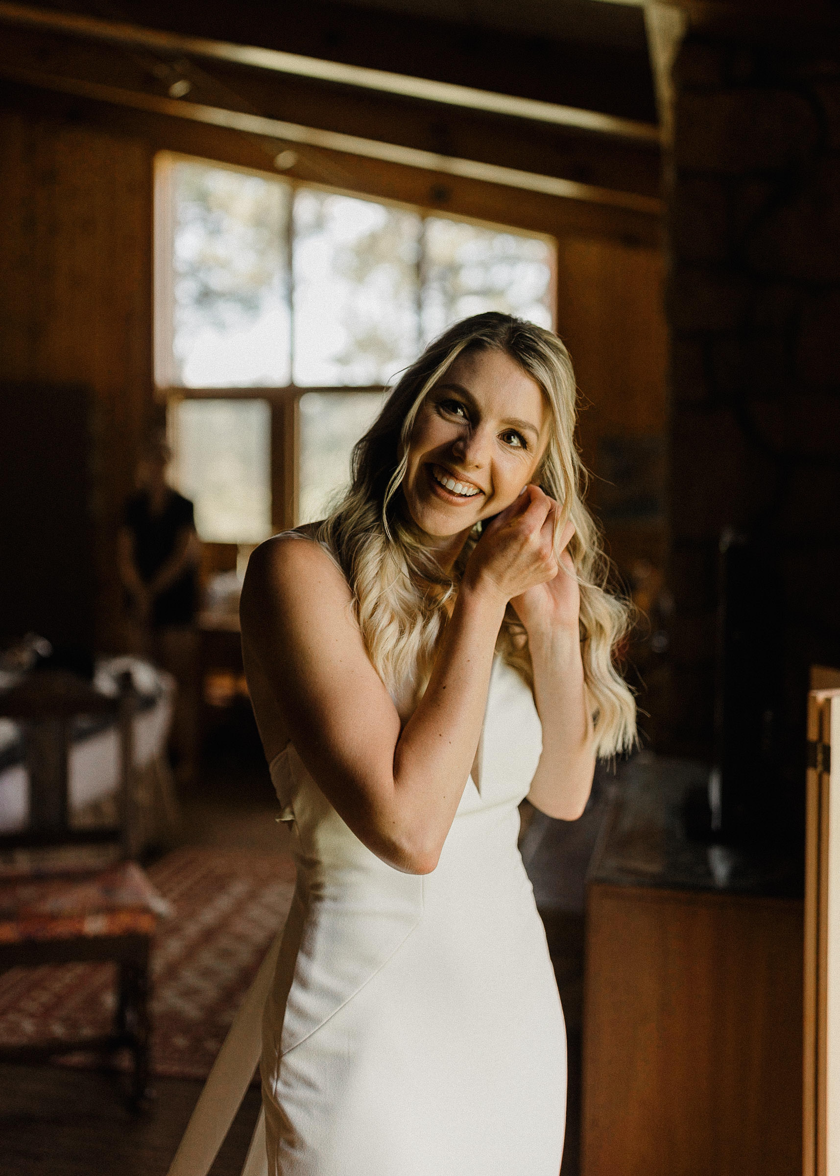 Bride putting on her earrings and smiling