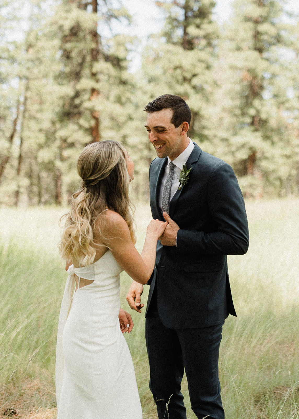 Groom sees bride for the first time during their "first look" in a field