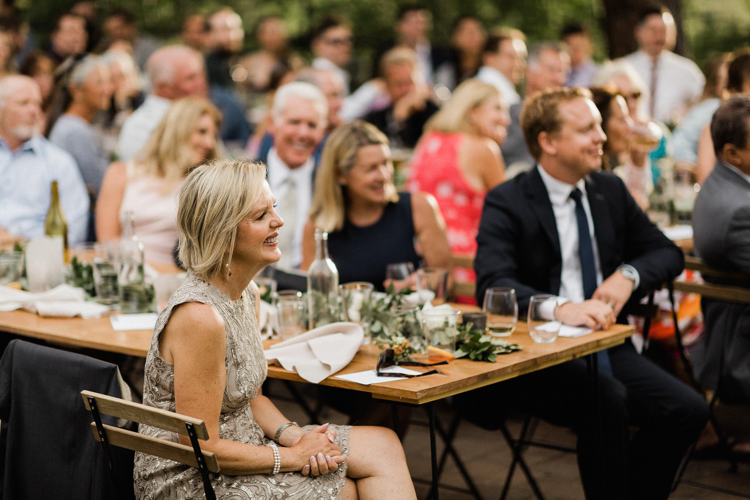 Bride's mom and brother smile as they watch the first dance