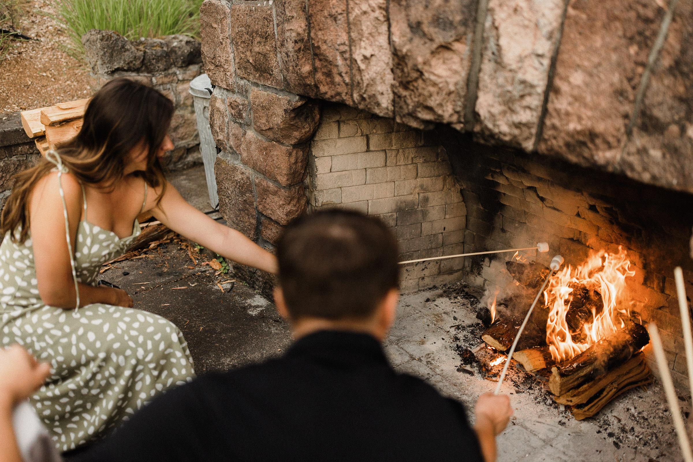 Guests roast marshmallows at an outdoor fireplace at House on the Metolius