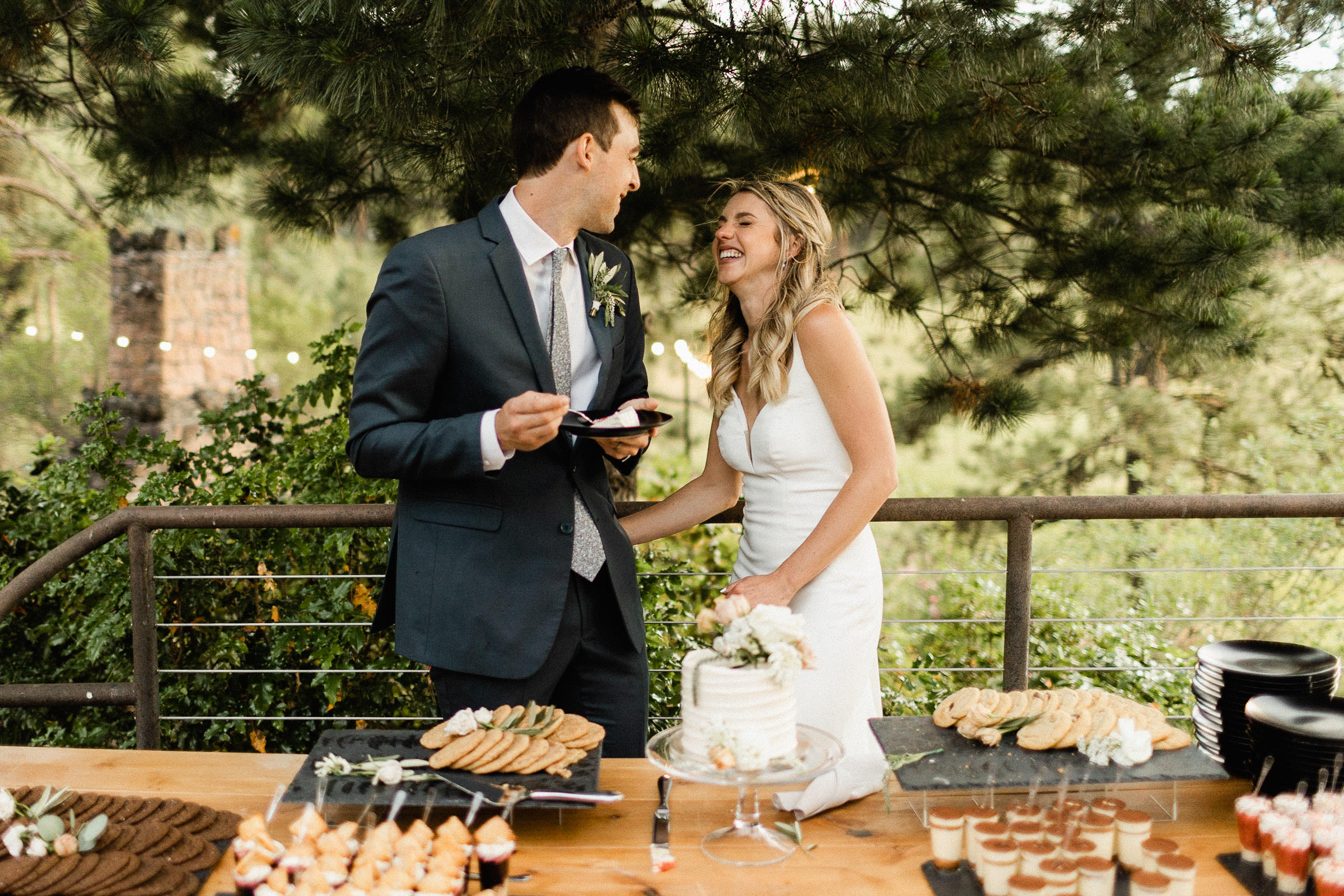 Bride and groom laugh after cutting cake