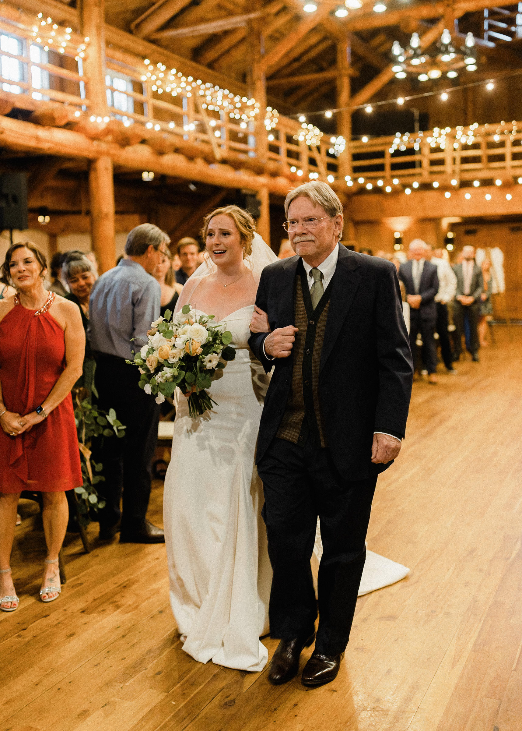 The bride and her father walk down the aisle during a wedding ceremony at Sunriver Resort's Great Hall